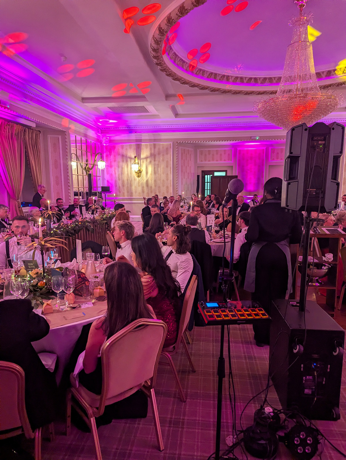 Corporate event at Manchester Hall with live 5-piece band and sax performing to seated guests under pink uplighting