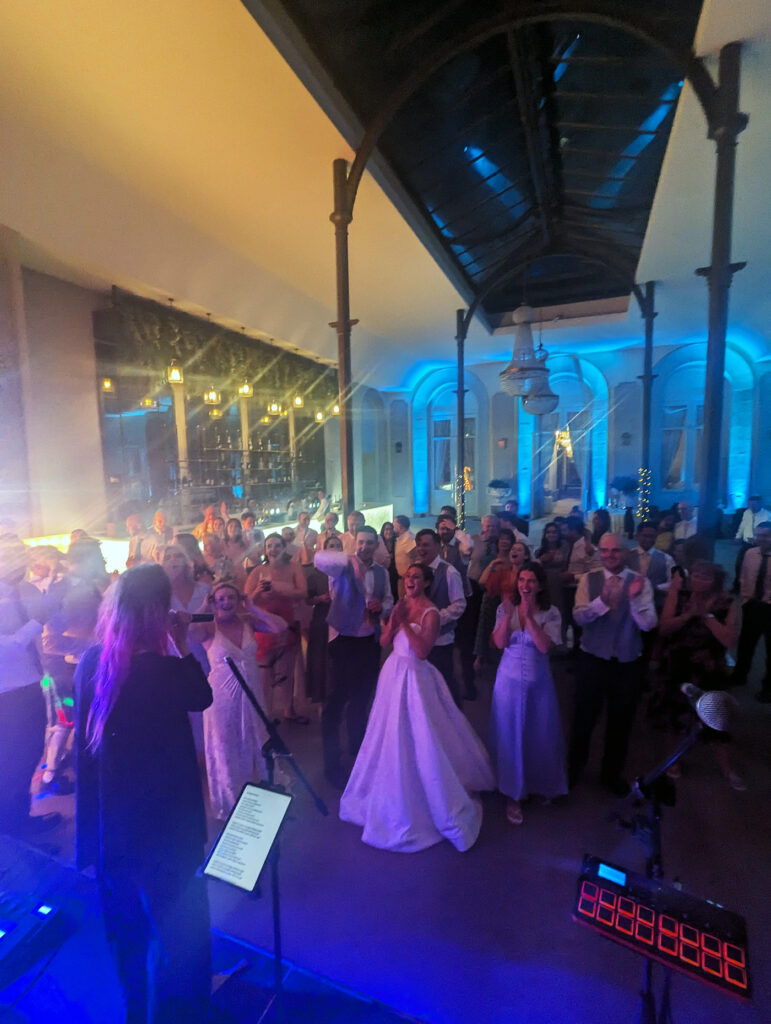 Bride and wedding guests singing and clapping during live band performance at Wynyard Hall.